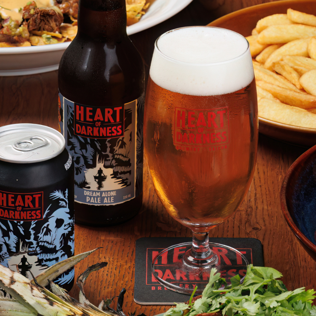 Table with beer, food, and 'Heart of Darkness' branding